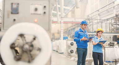industrial engineers inspecting machinery in modern factory production line